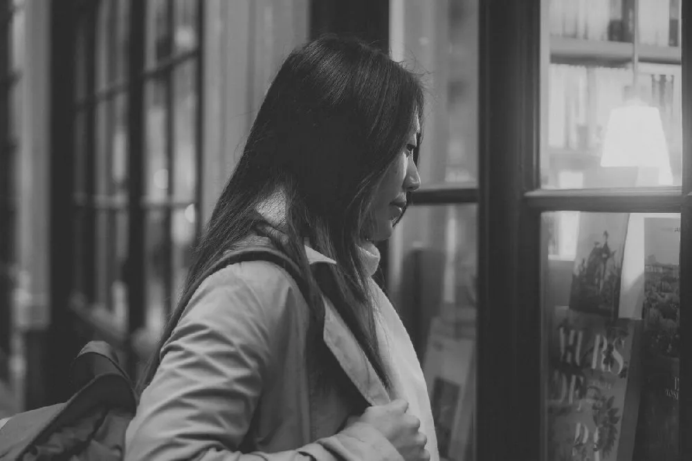 A lifestyle portrait by Arthur Fellig - a woman looking at books 1702648473079