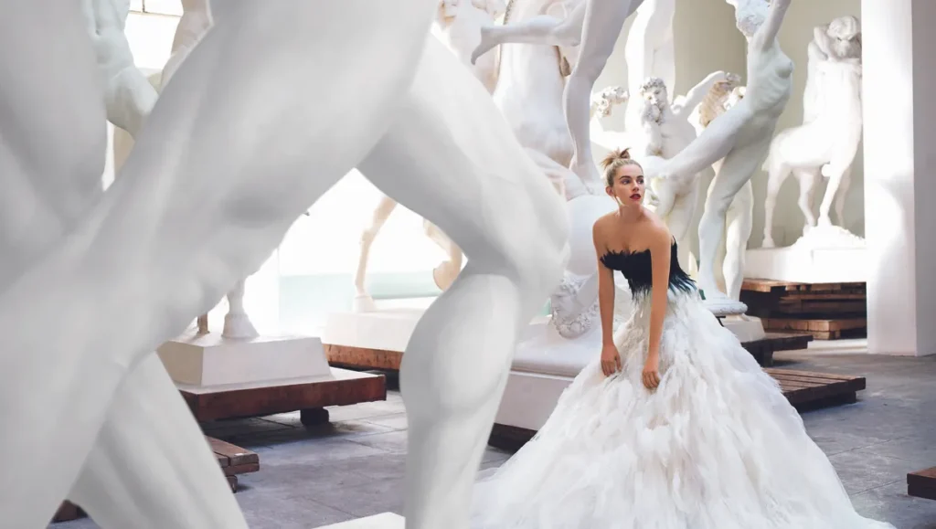 A conceptual portrait by Mario Testino - a woman standing next to sculptures 1702647602440